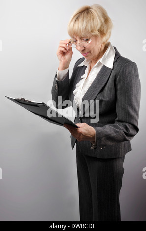 Attraktive Frau 50 Jahre alt mit einem Notizblock in Händen Stockfoto
