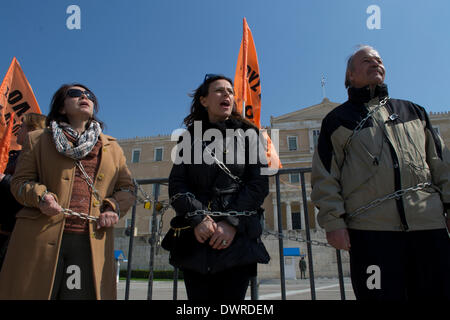 Athen, Griechenland, 12. März 2014. Lehrer sind gefesselt mit Ketten vor dem griechischen Parlament als Gewerkschaften des öffentlichen Sektors einen 24-Stunden-Streik um über Tausende protestieren inszeniert bevorstehenden Entlassungen. Bildnachweis: Nikolas Georgiou / Alamy Live News Stockfoto