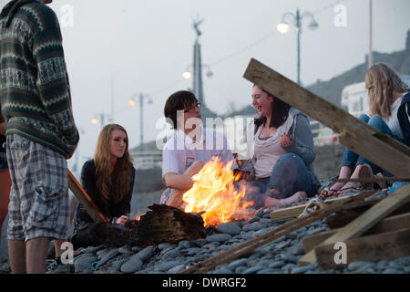 Aberystwyth Wales UK, Mittwoch, 12. März 2014 Gruppen von Studenten Genießen Barbecues am Strand bei Sonnenuntergang am Ende eines anderen Tages feine warme sonnige Wetter in Aberystwyth an der Westküste Wales UK. Die anhaltende Zauber des warmen Wetters ständiger führte bei Temperaturen bis zu 15C am Nachmittag. Bildnachweis: Keith Morris/Alamy Live-Nachrichten Stockfoto