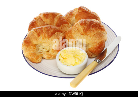 Croissants, Butter und ein Messer auf einem Teller isoliert gegen weiß Stockfoto