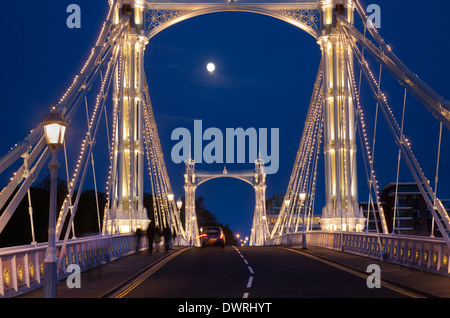 Albert Bridge über die Themse in London, mit Lichtern und der Mond scheint durch den Nachthimmel hinter geschmückt. Stockfoto