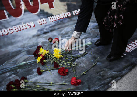 Madrid, Spanien. 11. März 2014. Eine Frau Tropfen erinnern Blumen während einer Veranstaltung außerhalb Atochas-Bahnhof in der Verkehrstoten im Madrid trainieren Bombenanschläge in Madrid, Spanien, Dienstag, 11. März 2014, im Gedenken der getöteten und Verletzten im Madrid trainieren Bombenanschläge, anlässlich des 10. Jahrestags von Europas schlimmste islamischen Terror-Anschlag. Die Angreifer gezielt vier s-Bahnen mit 10 Schrapnell-gefüllte Bomben in Rucksäcke im morgendlichen Berufsverkehr am 11. März 2004 verborgen. Bildnachweis: Rodrigo Garcia/NurPhoto/ZUMAPRESS.com/Alamy Live-Nachrichten Stockfoto