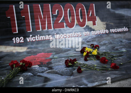 Madrid, Spanien. 11. März 2014. Blumen sind links auf ein Banner, dass Sais '' 11M 2004'' 192 unschuldige Opfer in unserem Gedächtnis '' während einer Veranstaltung außerhalb Atochas-Bahnhof in der Toten bei den Anschlägen von Madrid Zug in Madrid, Spanien, Dienstag, 11. März 2014 erinnern, im Gedenken der getöteten und Verletzten im Madrid trainieren Bombenanschläge, anlässlich des 10. Jahrestags von Europas schlimmste islamischen Terror-Anschlag. Die Angreifer gezielt vier s-Bahnen mit 10 Schrapnell-gefüllte Bomben in Rucksäcke im morgendlichen Berufsverkehr am 11. März 2004 verborgen. Bildnachweis: Rodrigo Garcia/NurPhoto/Z/Alamy Live Stockfoto
