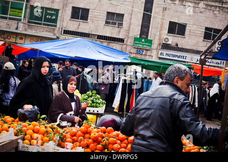 Zwei Frauen sprechen mit einem Lieferanten, da sie Obst auf dem Freitag-Markt in der Abdali Stadtteil von Amman kaufen, Jordanien. Stockfoto