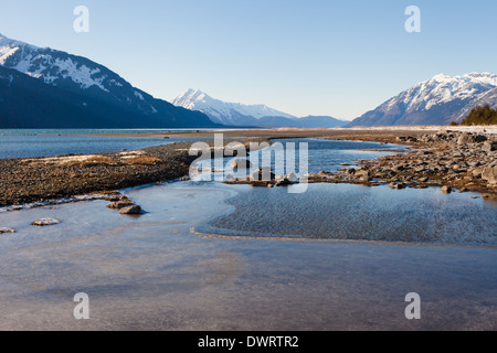 Das Wasser am Strand des Chilkat Inlet in der Nähe von Haines Alaska mit Bergen im Hintergrund. Stockfoto