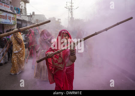 Mathura, Uttar Pradesh in Indien. 12. März 2014. Frauen benutzen Bambusstöcke, um Männer zu treffen, wie sie die Lathmar Holi in Mathura, Uttar Pradesh in Indien, 12. März 2014 feiern. Lathmar Holi ist ein lokales fest in Mathura, und es findet auch vor Holi-Nationalfeiertag am 17. März dieses Jahres. Bildnachweis: Zheng Huansong/Xinhua/Alamy Live-Nachrichten Stockfoto