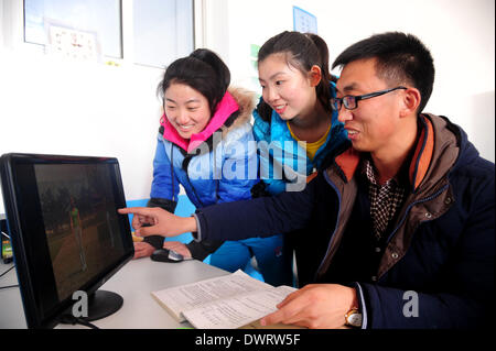 Shenyang. 13. März 2014. Freiwilliger Lehrer Jian Zhu (C) und Wang Ninghui (L), beide Junioren-Studenten der Sporthochschule Shenyang, wenden Sie sich an Lehrer an Xiaochengzi neun Jahre Ausbildung Schule Kangping County in Shenyang, Hauptstadt des nordöstlichen Chinas Liaoning Provinz. Rund 90 junior-Studenten aus Shenyang Sporthochschule wurden an Grund- und Mittelschulen in den Vororten von Shenyang als freiwillige Tearchers für ein halbes Jahr gesendet. © Zhang Wenkui/Xinhua/Alamy Live-Nachrichten Stockfoto