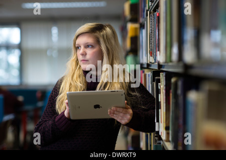 Ein junge blonde behaarte Frau undergraduate Student hält iPad studieren an der Aberystwyth University, Wales UK Stockfoto