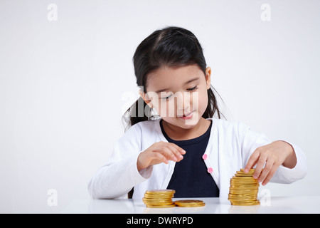 Schuss von einem Kind mit Goldmünzen hautnah Stockfoto