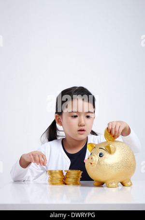 Schuss von einem Kind mit Goldmünzen hautnah Stockfoto