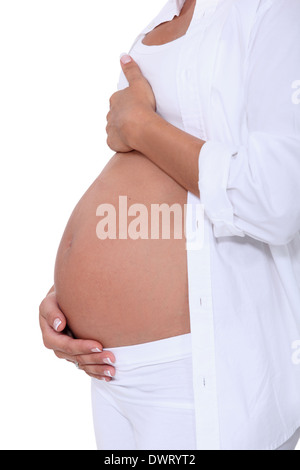 Frau umarmt ihren schwangeren Bauch Stockfoto