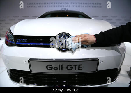 Berlin, Deutschland, 12. März 2014. Ein Mitarbeiter Polituren ein Golf GTE-Auto auf der Jahrespressekonferenz des deutschen Automobilherstellers Volkswagen (VW) auf dem ehemaligen Flughafen Tempelhof in Berlin. Foto: MICHAEL KAPPELER/Dpa/Alamy Live News Stockfoto