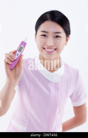 eine Krankenschwester posiert mit einem thermometer Stockfoto