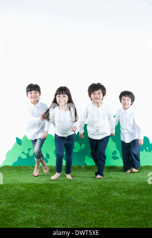 vier Kinder spielen auf dem Rasen Stockfoto
