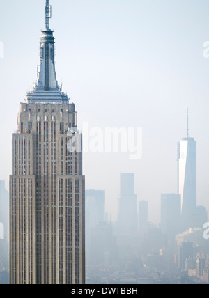 Das Empire State Building und das neue One World Trade Center von der Rockefeller Building gesehen an einem nebligen Tag in New York Stockfoto