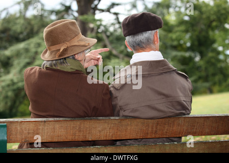 Älteres Paar sitzt auf einer Parkbank Stockfoto