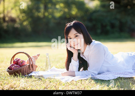 eine Frau liegt auf dem Rasen Stockfoto