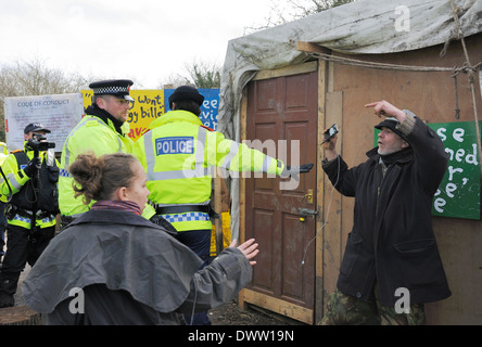 Polizistin steht vor ein Demonstrant, ihn von einem TAU-Offizier zu schützen, die ihn heftig in den Holzschuppen geschoben. Stockfoto