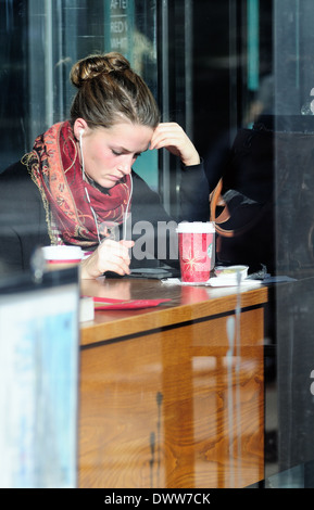 Menschen Coffee Shop einsamen Moment Frau an electronic device's Illinois Chicago Michigan Avenue. Chicago, Illinois, USA. Stockfoto