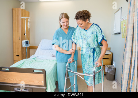 Krankenschwester hilft Patienten gehen mit Walker im Krankenhaus Stockfoto