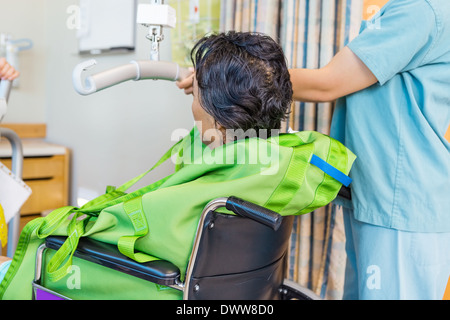 Krankenschwester Holding Hebebühne Griff mit Patienten im Rollstuhl Stockfoto