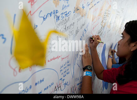 Kuala Lumpur, Malaysia. 13. März 2014. Eine Frau schreibt Nachrichten auf ein Banner für alle Beteiligten mit dem fehlenden malaysischen Flugzeug am der Kuala Lumpur International Airport in Sepang, Malaysia, 13. März 2014 gewidmet. Bildnachweis: He Jingjia/Xinhua/Alamy Live-Nachrichten Stockfoto