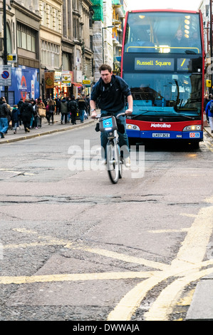 Radfahrer mit blauem Barclay Fahrrad ins New Oxford Street, vorbei an der Tottenham Court Road Kreuzung Stockfoto