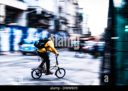 London, UK - 3. März 2014: Radfahrer mit einer hellen Gelb-Jacke ist eine Rechtskurve in Tottenham Court Road, London statt. Stockfoto