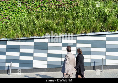 Zwei Menschen zu Fuß Vergangenheit und Blick auf die lebendige Mauer auf Marken und Spencers Store auf Norwick Norfolk UK Stockfoto