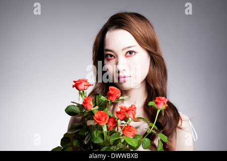 eine Frau mit schweren roten Make-up und Rosen Stockfoto