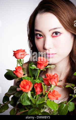 eine Frau mit schweren roten Make-up und Rosen Stockfoto