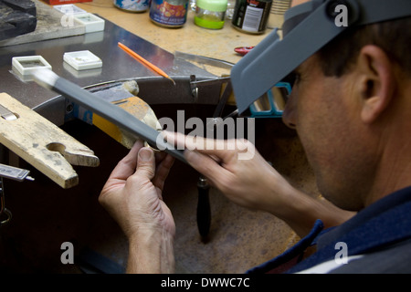 Simbabwe-italienischer Goldschmied Roberto Spagnuolo ist die Einreichung einer gelb-goldene Hochzeit Band um eine glatte Oberfläche zu gewährleisten. Model Released Stockfoto