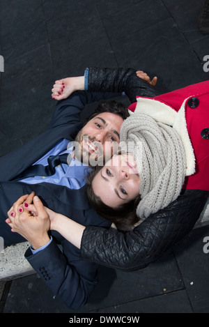 Mann und Frau belogen nach unten auf einer Bank Stockfoto