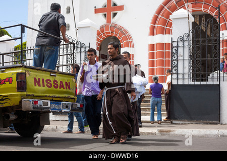 Ein Mönch grüßt einen Mann außerhalb der Kirche des Schwarzen Christus in Juayua auf die Rutas De La Flores in El Salvador Stockfoto