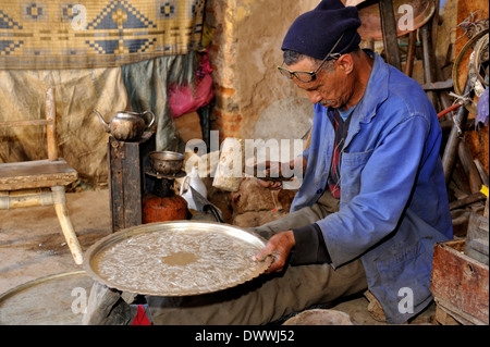 Metall Smith in kleinen Werkstatt aus einem der Souks in der Nähe von Place Djemaa El Fna machen serving Tray Marrakesch, Marokko, Nordafrika Stockfoto