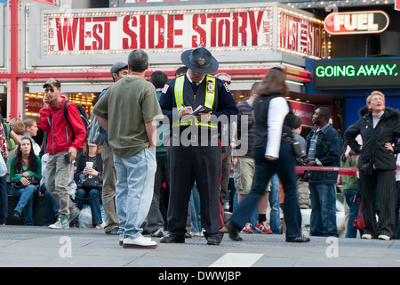 Polizist in Warnschutz Weste Times Square am Times Square mit Werbung für West Side Story Spielen im Hintergrund, New York, USA Stockfoto