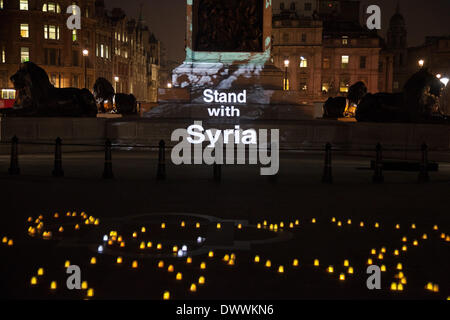 London, UK. 13. März 2014. Nelson Säule auf dem Trafalgar Square in London mit Kunstwerken von Banksy als Bestandteil einer Mahnwache, leuchtet um die Ständer mit Syrien-Kampagne zu starten. Die Kampagne soll unterstreichen, die der Krieg in Syrien geht schon seit drei Jahren am 15. März und die den Krieg beenden muss. Bildnachweis: Kristian Buus/Alamy Live-Nachrichten Stockfoto