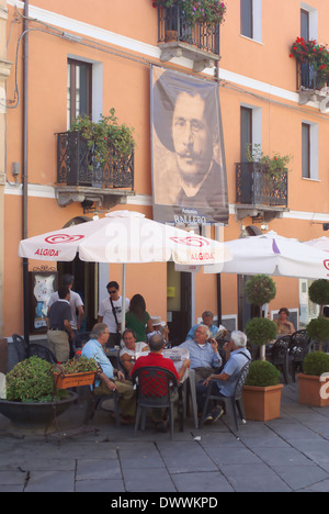 Menschen sitzen vor Café in Sardinien.