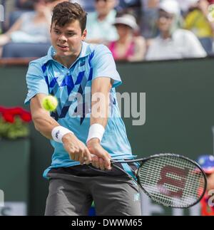 Los Angeles, Kalifornien, USA. 13. März 2014. Milos Raonic, von Kanada, gibt den Schuss gegen Alexandr Dolgopolov, der Ukraine, während ein Viertelfinalspiel bei der BNP Paribas Open Tennisturnier, Donnerstag, 13. März 2014, in Indian Wells, Kalifornien zurück. Dolgopolov gewann 6-3, 6-4. Bildnachweis: Ringo Chiu/ZUMAPRESS.com/Alamy Live-Nachrichten Stockfoto