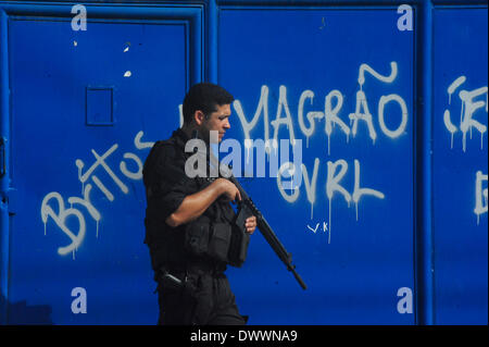 Rio De Janeiro, Brasilien. 13. März 2014. Polizei in Pflicht wachen die Umgebung der Villa Kennedy in Bangu, in der westlichen Zone von Rio. Polizei-Beruf noch weiter in den Favelas in Rio. Die Besatzung wird in einer Zeit der großen Spannungen in der Region stattfinden, wie Zusammenstöße zwischen Polizei und Droge Menschenhändler häufig gewesen. Über hundert tausend Menschen leben in der Region. (Foto von Fabio Teixeira / pazifische Presse/Alamy Live News) Stockfoto