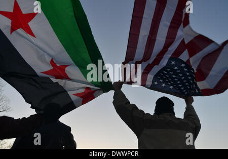 Wahsinton, DC, USA. 13. März 2014. Aktivisten halten der syrischen und amerikanische Flaggen während eine Mahnwache für den dritten Jahrestag des syrischen Bürgerkrieges auf der National Mall in Washington, DC an einem kalten und stürmischen Donnerstag.  Bildnachweis: Miguel Juarez Lugo/ZUMAPRESS.com/Alamy Live-Nachrichten Stockfoto