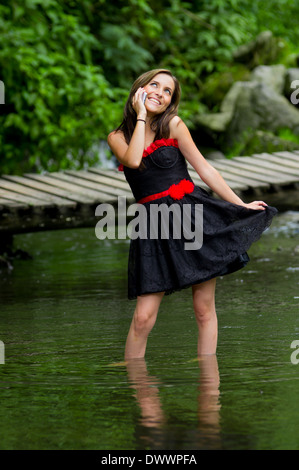 Junge attraktive Frau trägt ein Kleid sprechen auf dem Handy, im See Stockfoto