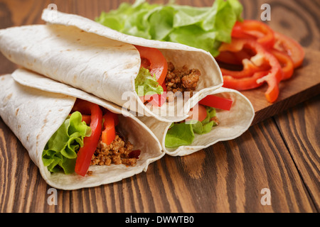 Burrito mit Fleisch und Zutaten nach dem alten Holztisch rustikalen Stil Stockfoto