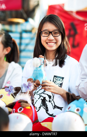 Junges Mädchen hält ein Spielzeugpferd an Neujahr-Jahrmarkt im Victoria Park, Hong Kong Stockfoto