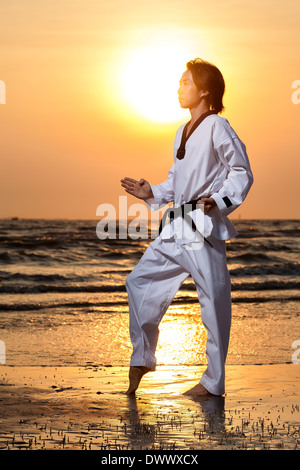 Martial Arts Mann Training Taekwondo bei Sonnenuntergang Stockfoto