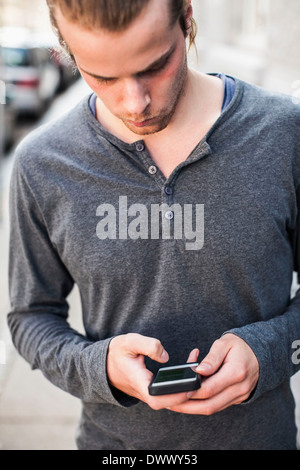 Junger Mann mit Handy im freien Stockfoto