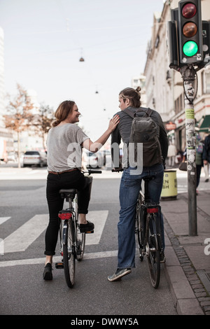 Rückansicht des Paares mit Fahrrädern warten auf Zebrastreifen an Stadtstraße Stockfoto