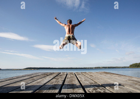 Rückansicht des reifen Mannes ins Meer tauchen Stockfoto