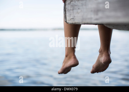 Geringer Teil der Frau baumelnden Füße vom pier Stockfoto