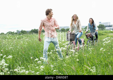 Junge Freunde Radfahren durch Feld Stockfoto